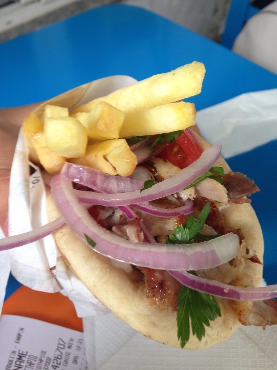 Pita gyros with fries, tomato, onion and herbs